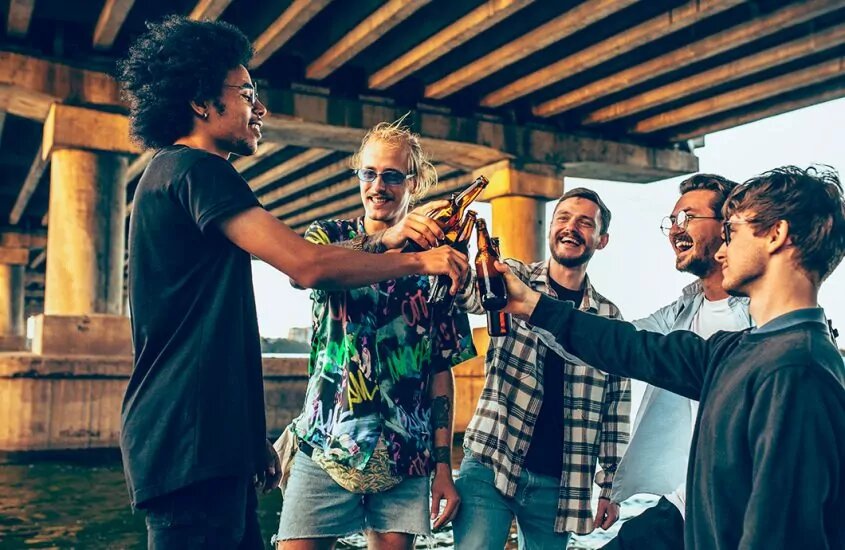Friends raising a toast with beer bottles