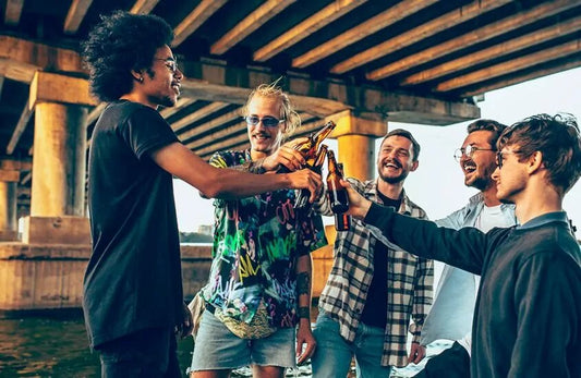 Friends raising a toast with beer bottles