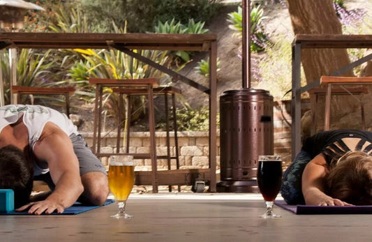 Two people doing yoga next to two glasses of beer