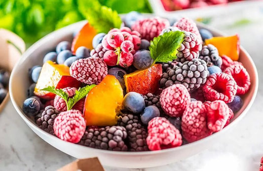 Bowl of fruits such as raspberries, blackberries, blueberries, and peaches. 