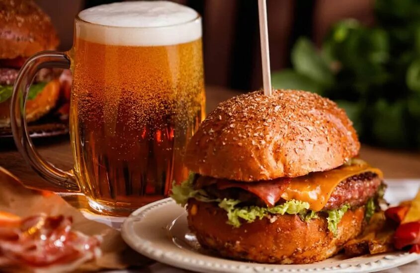 Glass of beer with a hamburger