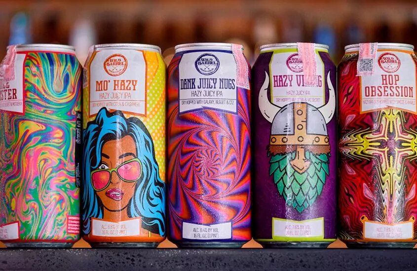 Beer cans with vibrant designs sit next to each other