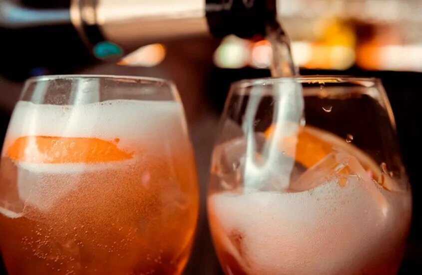 Two glasses of rose beer being filled