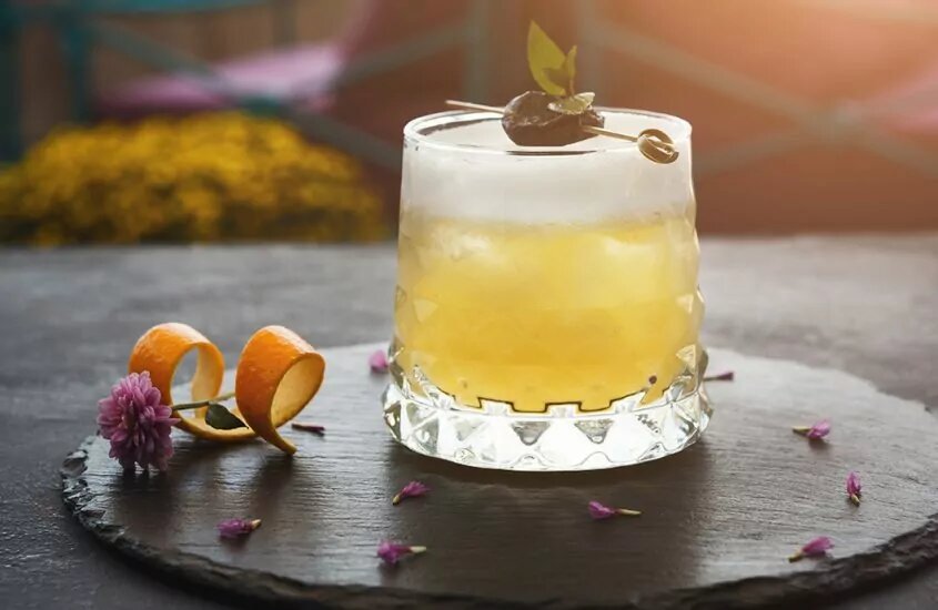 Glass of a beer cocktail on a black tray