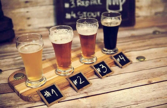 four glasses of beer are on a table next to each other labeled from one to four. 