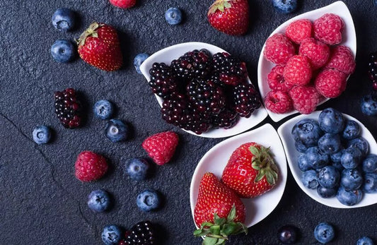  Bowls of blackberry, strawberry, raspberry, and blueberries lay next to each other
