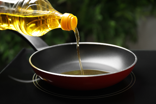 Oil being poured into a pan